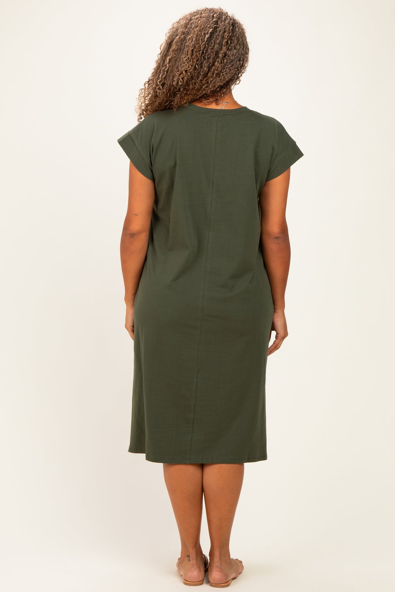 woman wearing a short sleeve olive green plus size dress, viewed from the back