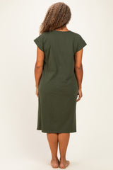 woman wearing a short sleeve olive green plus size dress, viewed from the back