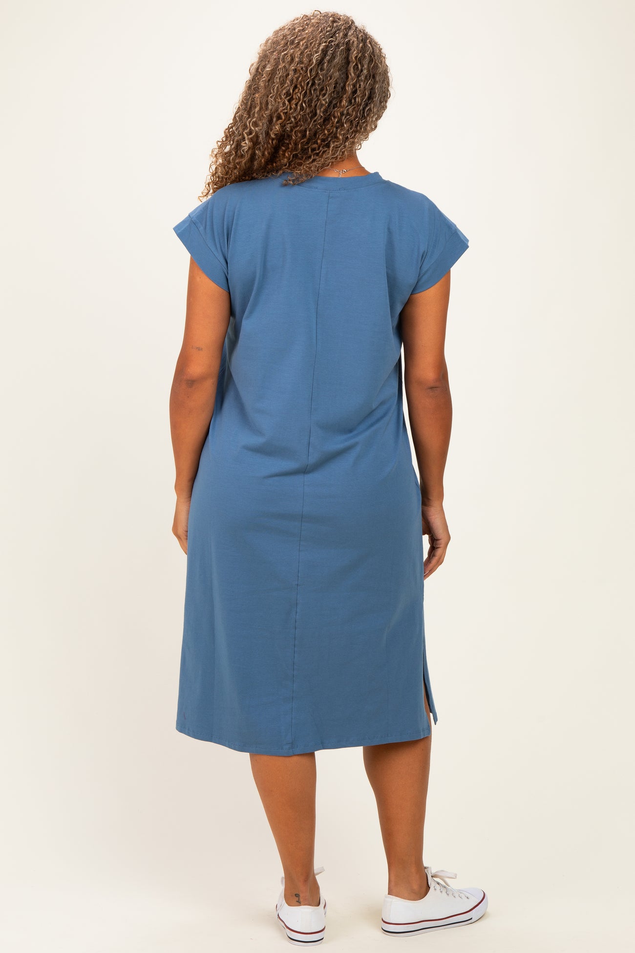 woman wearing a blue short sleeve plus size dress with a back slit and a relaxed fit