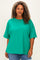 woman wearing a bright green oversized t-shirt with short sleeves and a relaxed fit, smiling at the camera