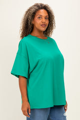 woman wearing a bright green oversized t-shirt with short sleeves and a relaxed fit, paired with denim jeans