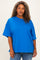 woman wearing a bright blue oversized t-shirt with short sleeves and a relaxed fit, paired with denim jeans