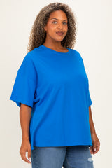 woman wearing a bright blue oversized t-shirt with short sleeves and paired with denim jeans