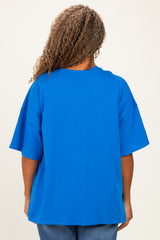 plus size woman wearing a bright blue oversized t-shirt, view from the back, with curly hair