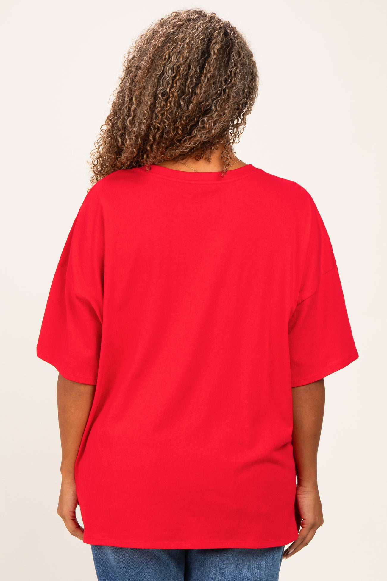 woman wearing a loose-fitting red oversized t-shirt viewed from the back