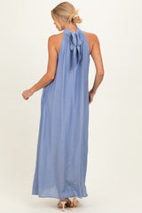 woman wearing a light blue sleeveless maternity maxi dress with a bow tie detail at the back
