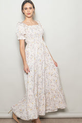 woman wearing a light pink floral maxi dress with puff sleeves and a smocked bodice