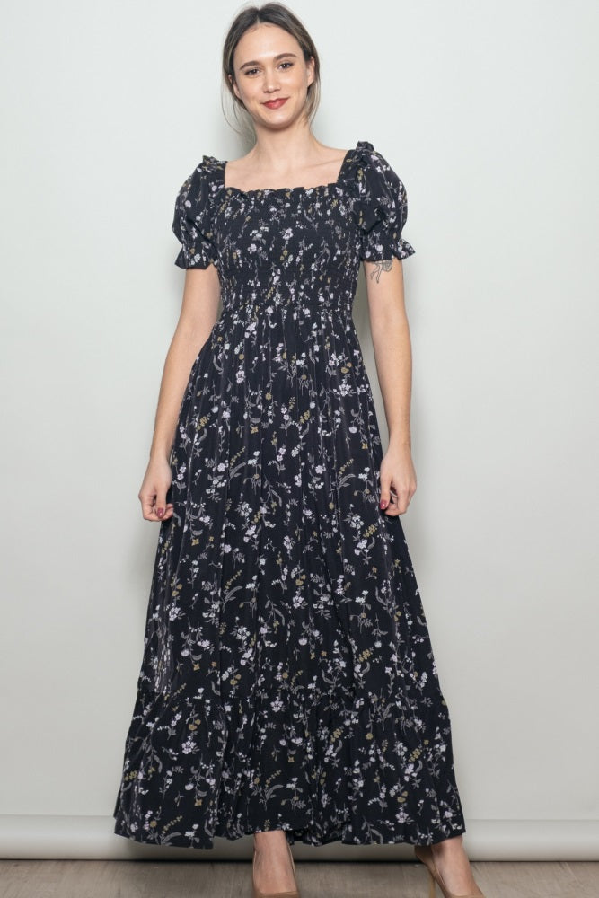 woman wearing a black floral maxi dress with short puff sleeves and a square neckline