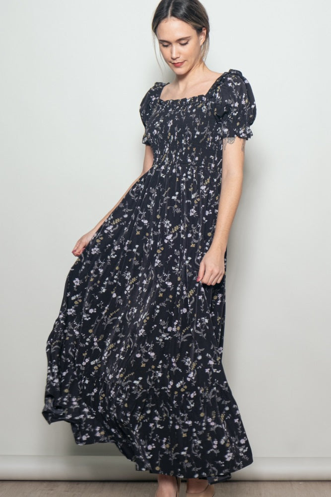 woman wearing a navy floral maxi dress with puff sleeves and a fitted bodice