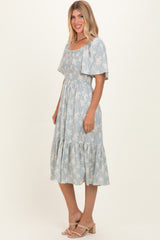 woman wearing a blue floral midi sundress with smocked bodice and flutter sleeves