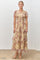 woman wearing a floral tiered maxi dress with short puff sleeves in shades of beige and pink.