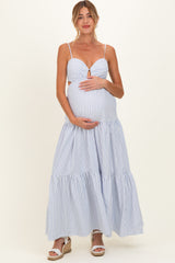 woman wearing a blue and white striped maternity maxi dress, holding her baby bump with a smile