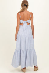 woman wearing a blue and white striped maternity maxi dress with a back tie detail and tiered skirt