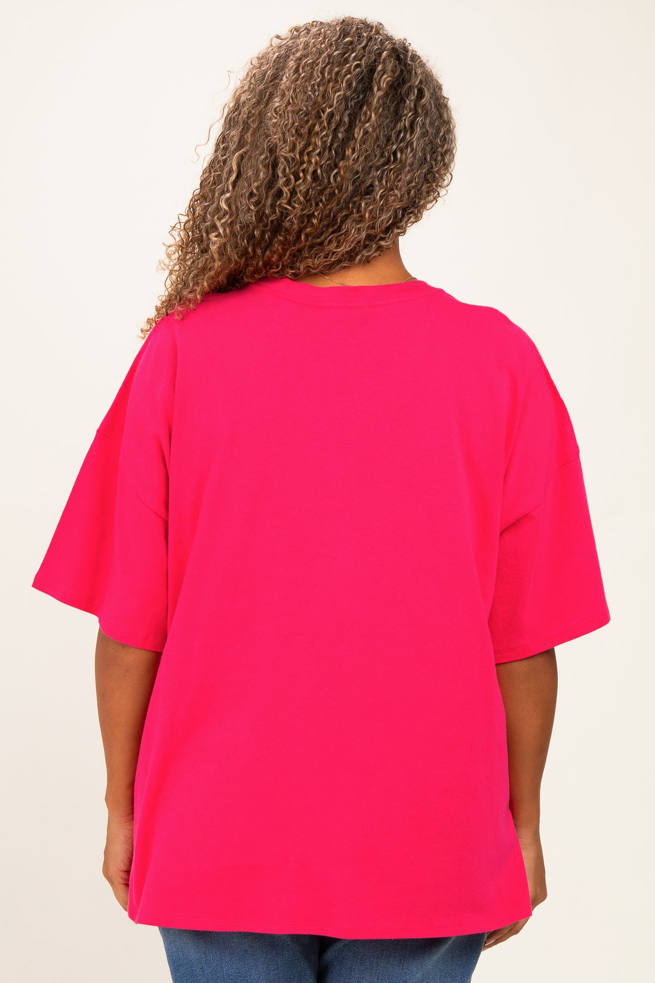 plus size woman wearing a bright pink oversized t-shirt from the back