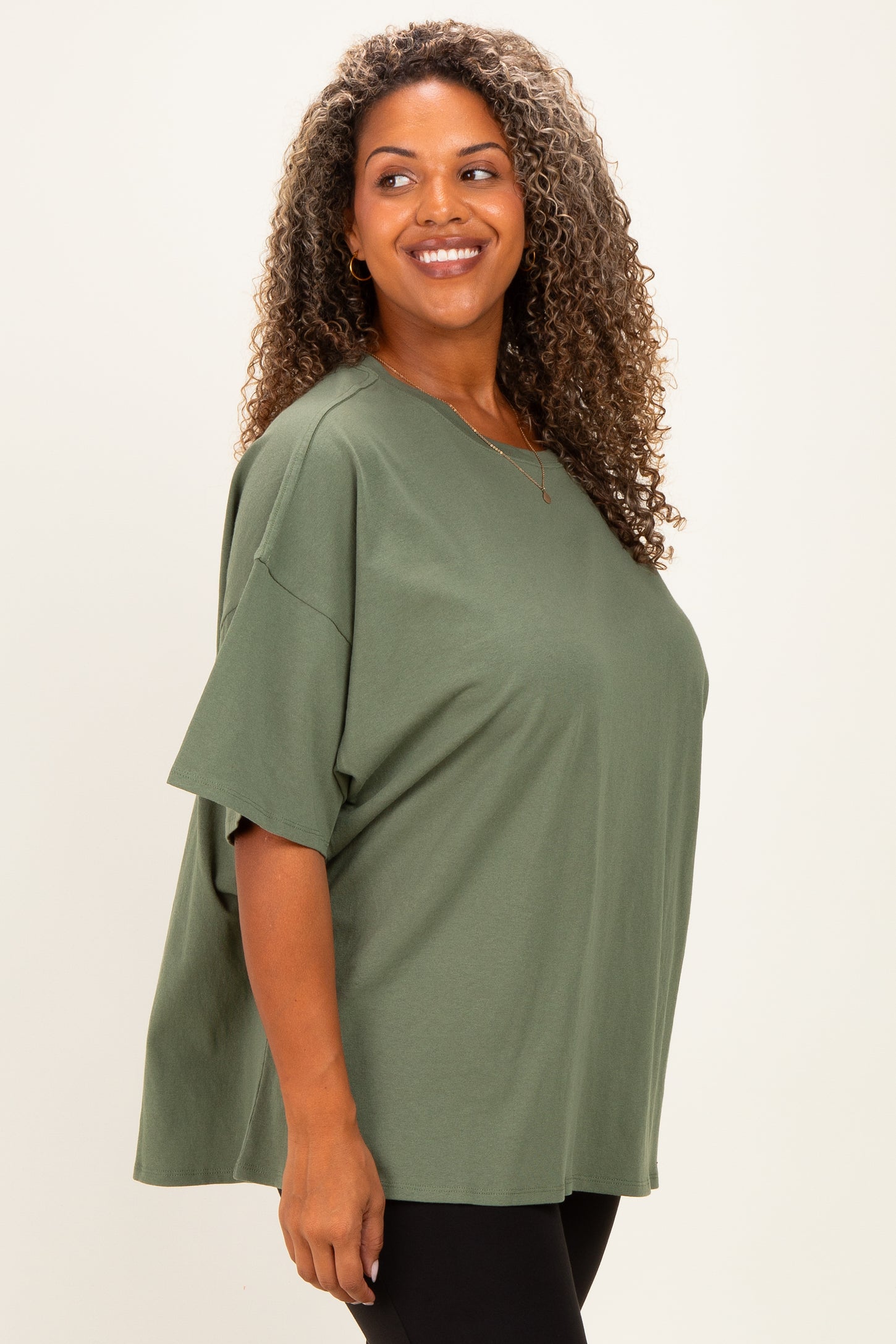 woman wearing a loose-fitting olive green plus size t-shirt with short sleeves and a round neckline