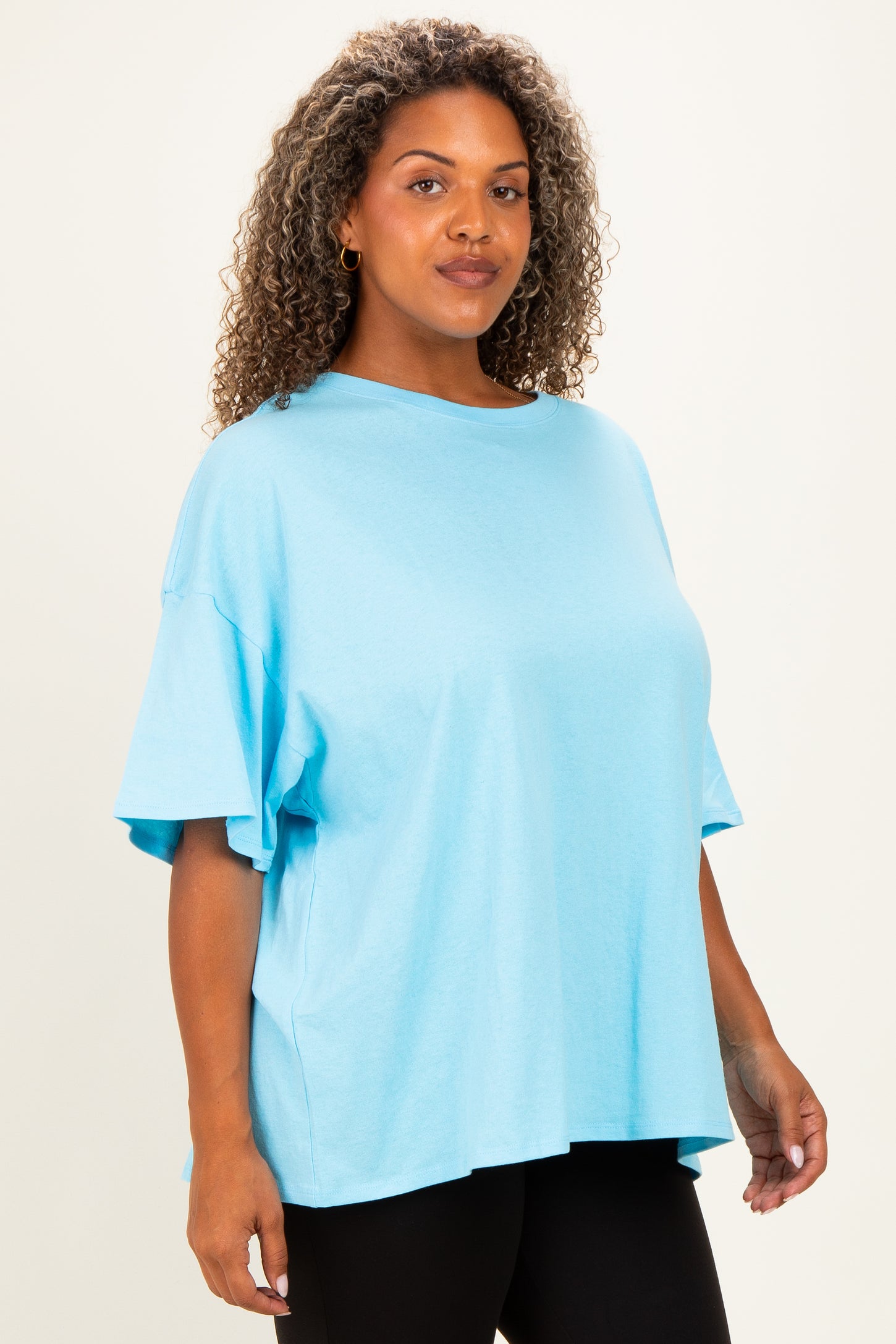woman wearing a light blue oversized t-shirt with short sleeves and a loose fit