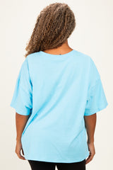 woman wearing a blue oversized short sleeve t-shirt viewed from the back, paired with black leggings
