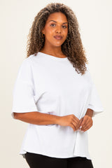 woman wearing a white oversized t-shirt with short sleeves and a relaxed fit, styled with black pants