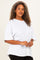 woman wearing a white oversized t-shirt with short sleeves and a relaxed fit, styled with black pants