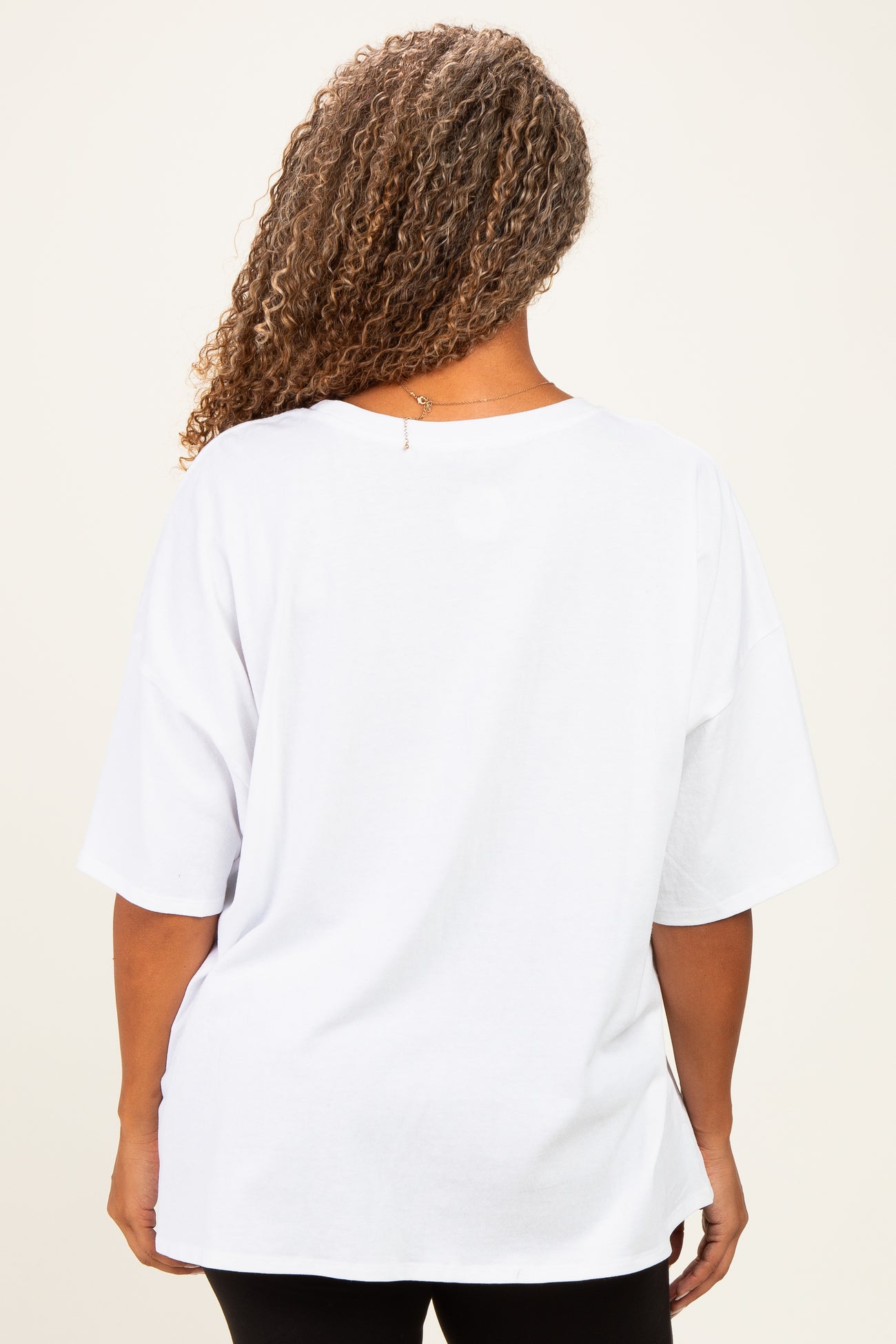 plus size woman wearing a loose-fitting white oversized t-shirt viewed from the back