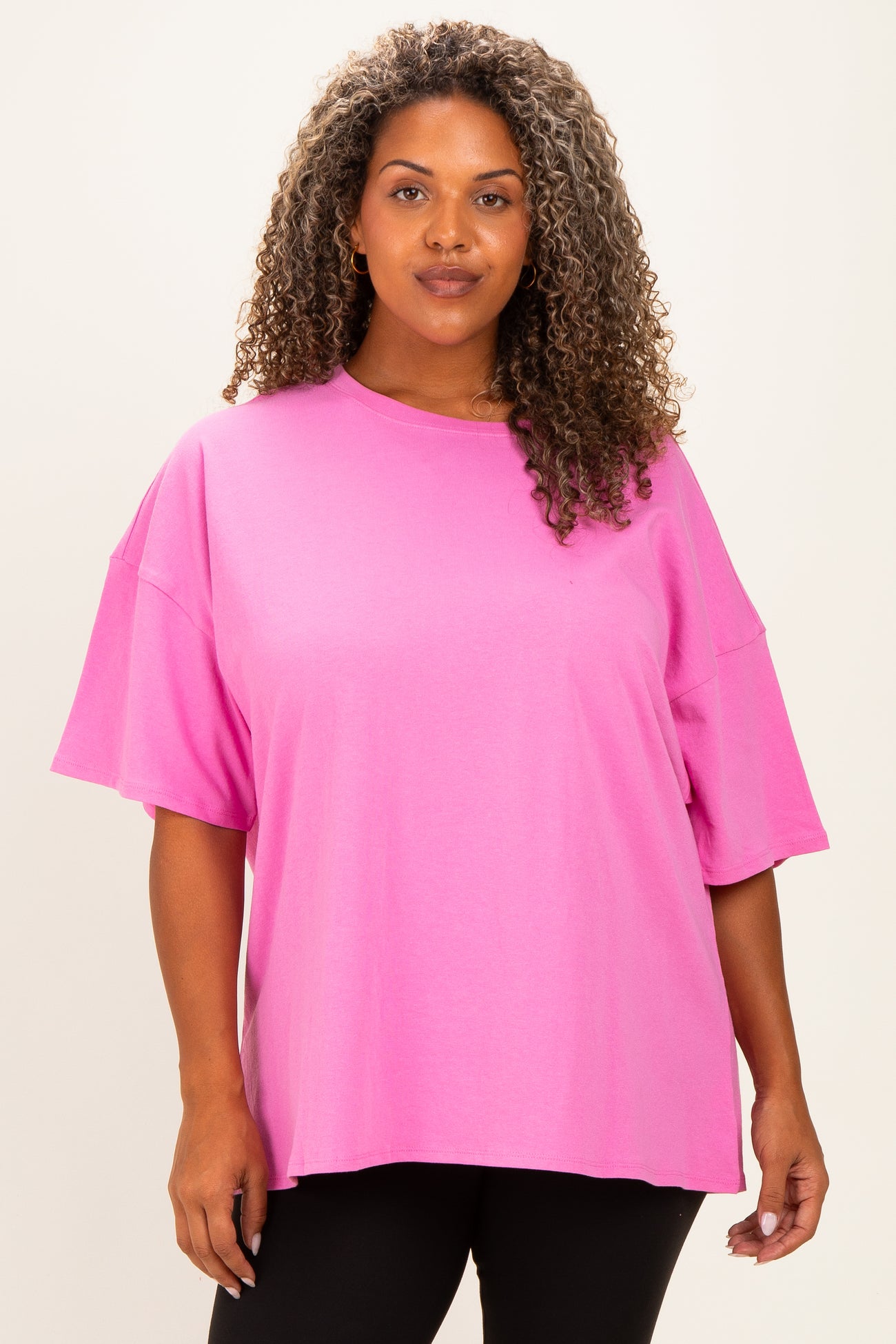 woman wearing a bright pink oversized t-shirt with short sleeves and a relaxed fit