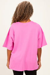 woman wearing a bright pink oversized t-shirt, viewed from the back, with short sleeves and relaxed fit