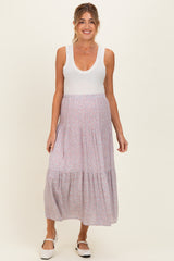 woman wearing a white ribbed maternity tank top and a floral maxi skirt, showing a baby bump