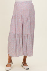 woman wearing a floral print maternity midi skirt with tiered design and comfortable elastic waistband