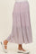 woman wearing a light pink floral maternity maxi skirt with tiered ruffles and a visible baby bump