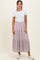 woman wearing a white short sleeve top and a pink floral tiered maxi skirt with white sneakers