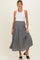 woman wearing a white tank top and a black and white floral print maternity skirt with ruffle detail