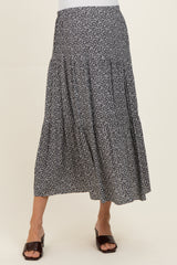 woman wearing a black and white floral print maternity maxi skirt with tiered details and a relaxed fit