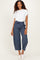 woman wearing a white t-shirt and navy striped wide-leg pants with a drawstring waist and white sneakers
