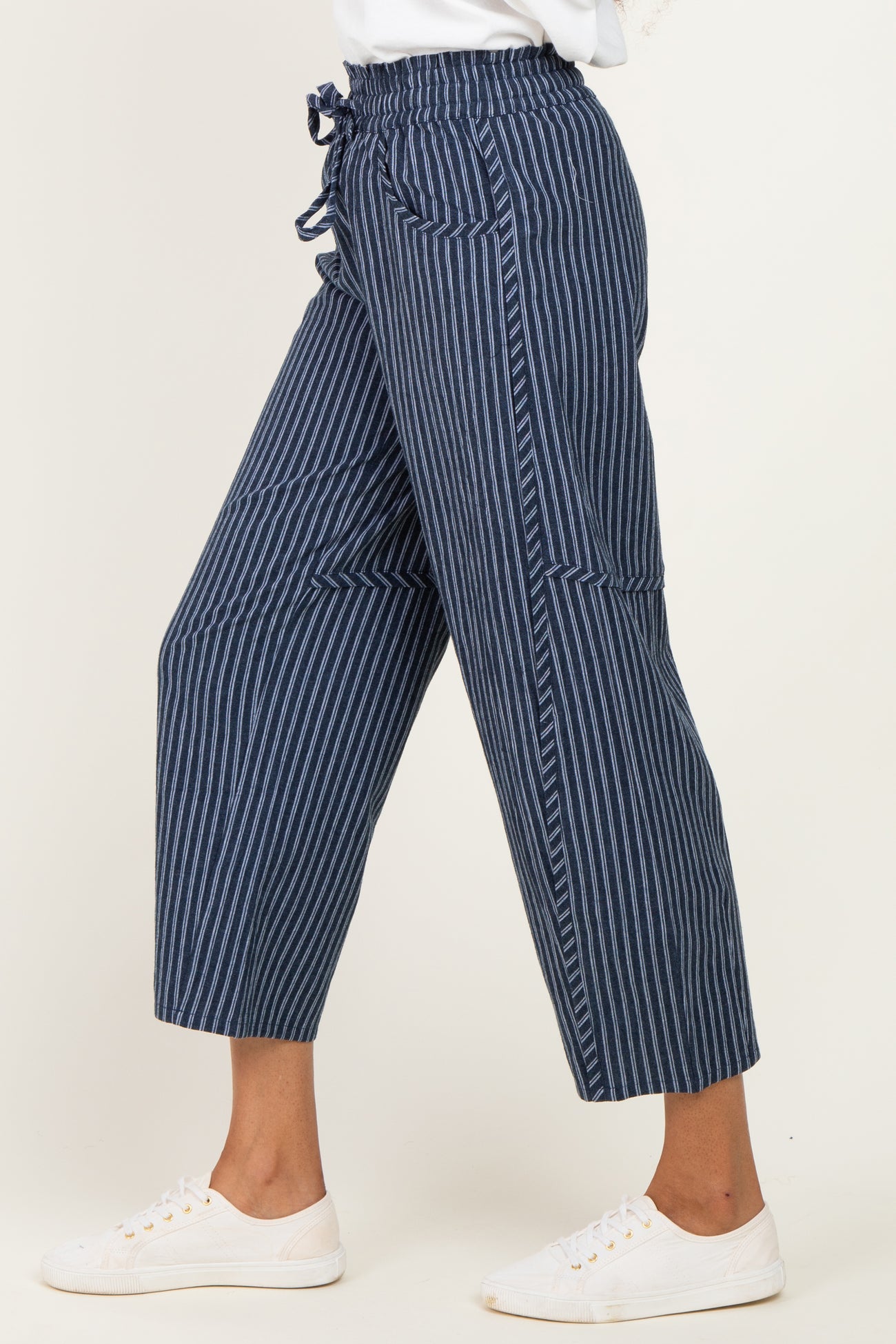 woman wearing navy blue and white striped cropped pants with a drawstring waist and side pockets
