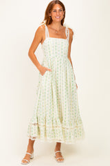 woman wearing a green and white patterned maxi dress with lace straps and pockets