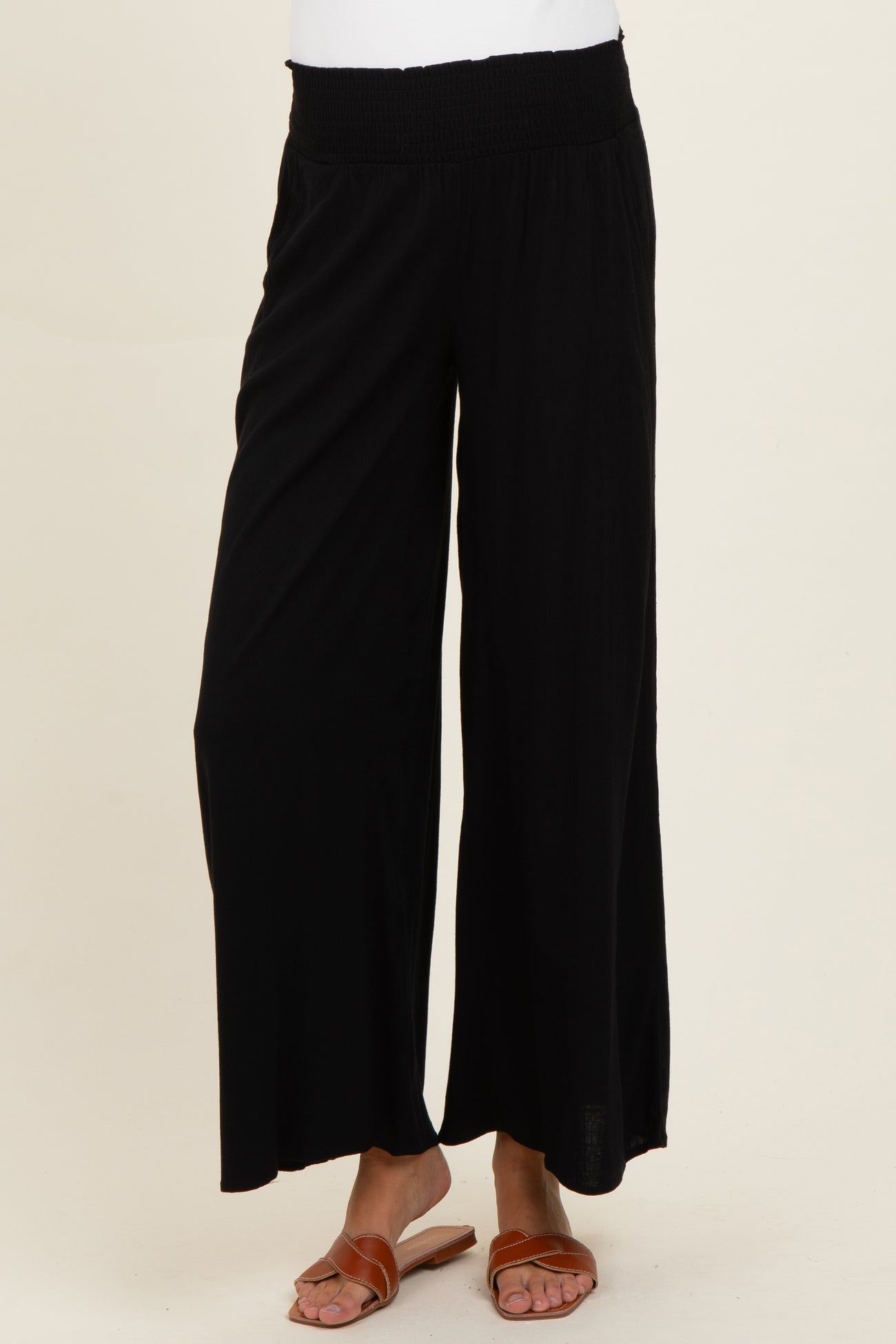 woman wearing black wide-leg maternity pants with a stretchy waistband and sandals
