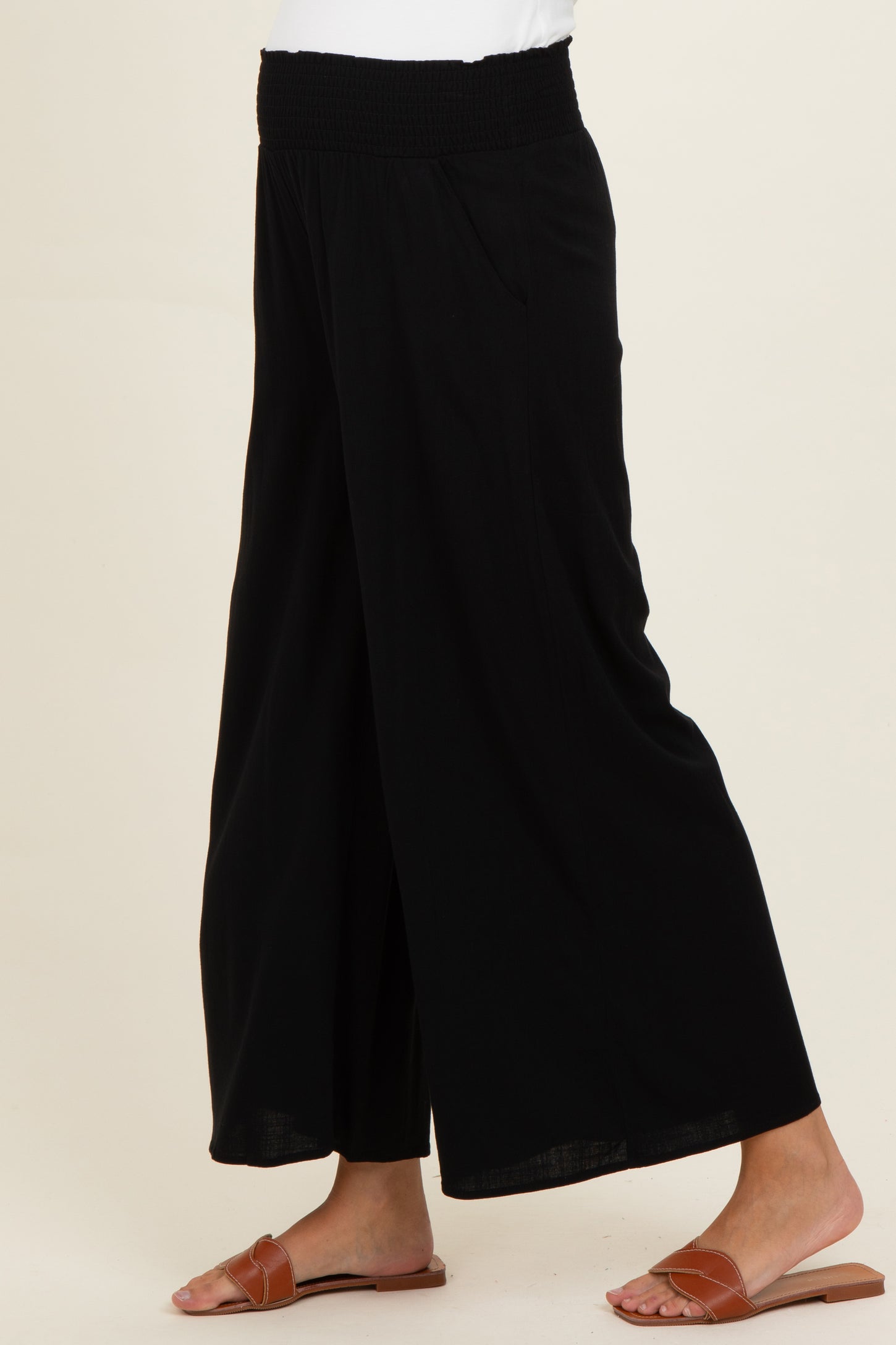 woman wearing black maternity wide-leg pants with a smocked waistband and pockets