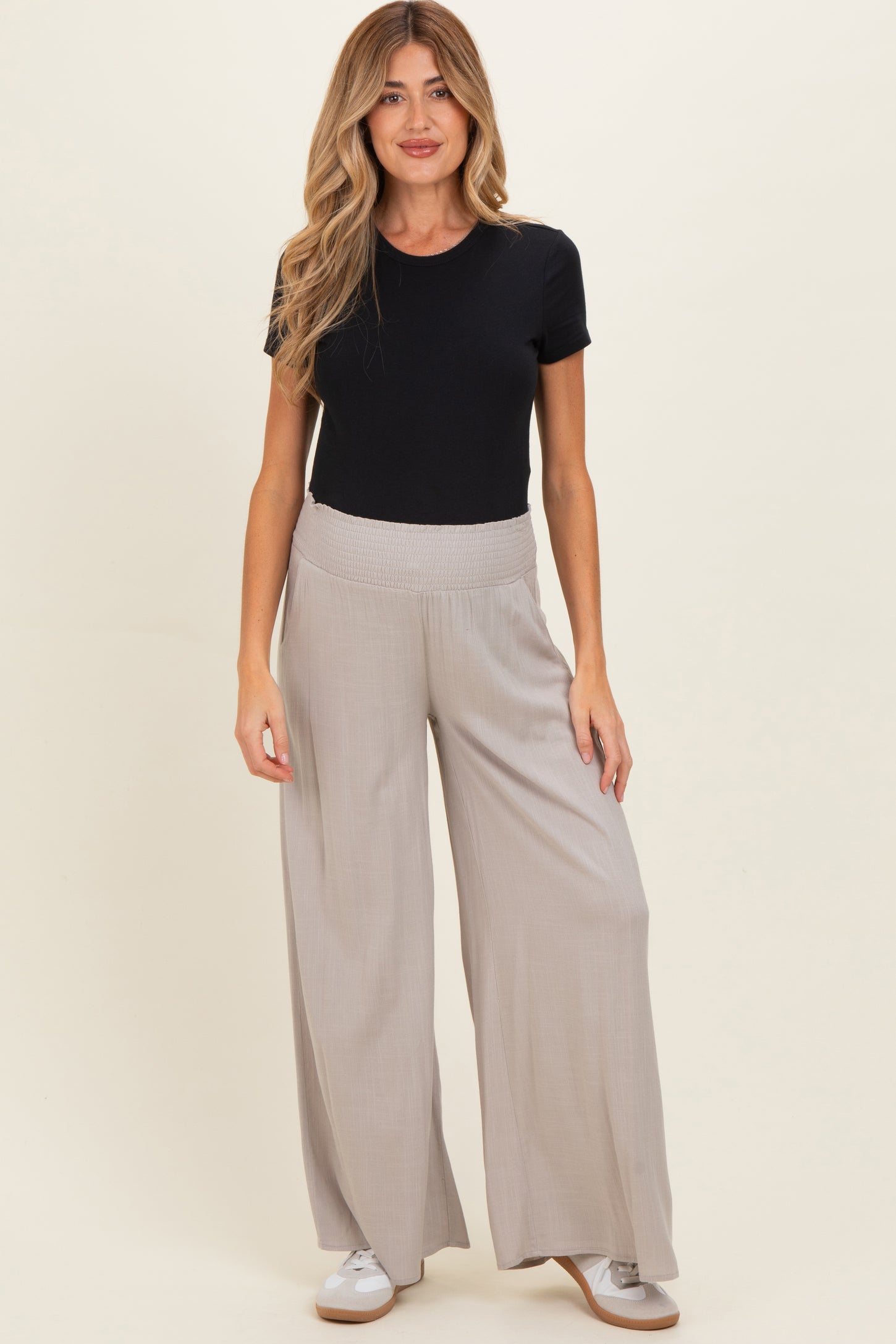 woman wearing a black short sleeve shirt and gray wide-leg maternity pants with a comfortable waistband