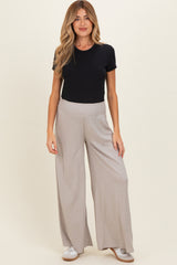 woman wearing a black short sleeve shirt and gray wide-leg maternity pants with a comfortable waistband