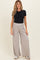 woman wearing a black short sleeve shirt and gray wide-leg maternity pants with a comfortable waistband