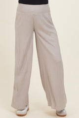 woman wearing light beige maternity wide-leg pants with a smocked waistband