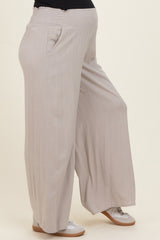 maternity wear light beige wide-leg pants with an elastic waistband and side pockets, worn by a model with a baby bump