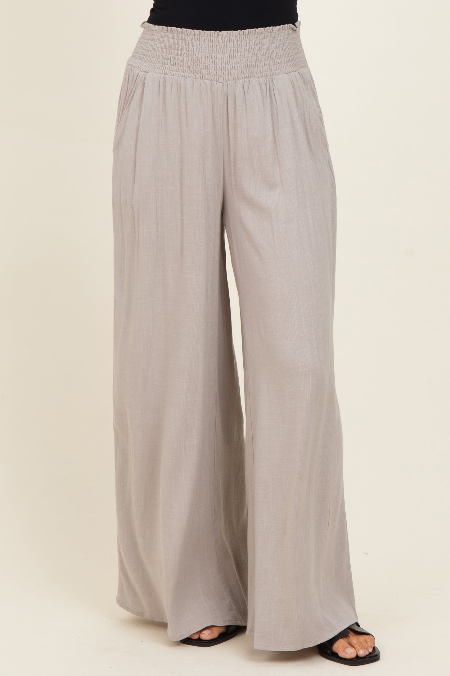 woman wearing light gray wide-leg pants with a smocked waist and casual fit