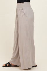 light gray wide-leg pants with a smocked waistband and side pockets, styled on a model standing sideways