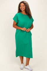 woman wearing a green plus-size midi dress with short sleeves and a pocket detail