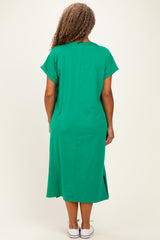 woman wearing a green short sleeve plus size dress with side slits and a relaxed fit, viewed from the back