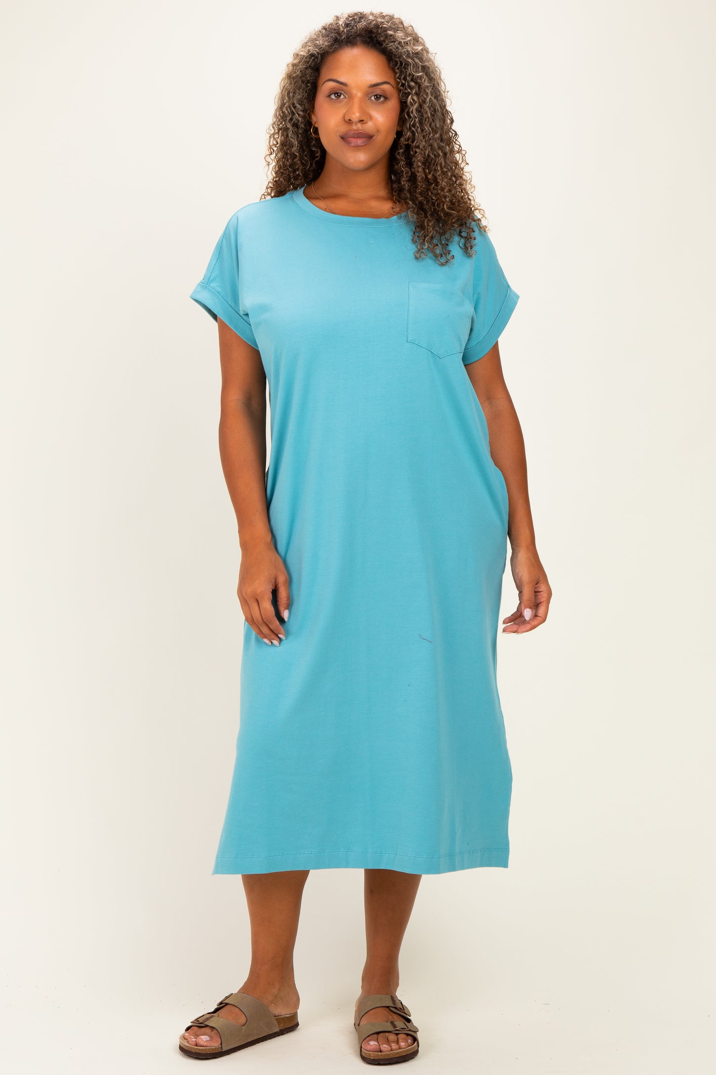 woman wearing a turquoise short sleeve plus size dress with a pocket and relaxed fit