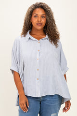 woman wearing a striped button-up shirt with short sleeves and a relaxed fit paired with distressed jeans