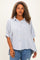 woman wearing a striped button-up shirt with short sleeves and a relaxed fit paired with distressed jeans