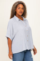 woman wearing a blue and white striped short sleeve button-up shirt paired with distressed denim jeans